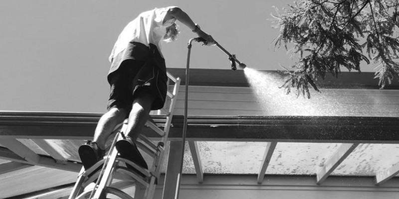 man cleaning cladding of the ladder