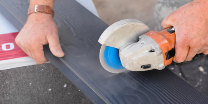 man cuts cedral board with angle grinder