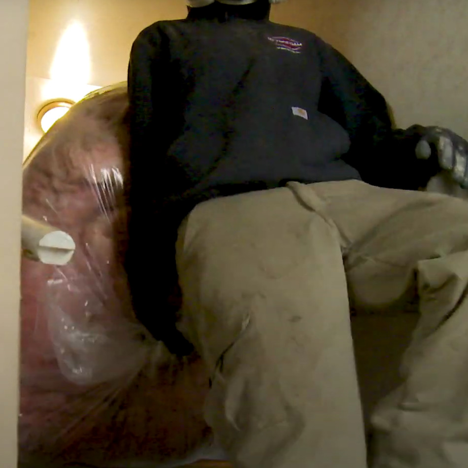 man removes old insulation from loft