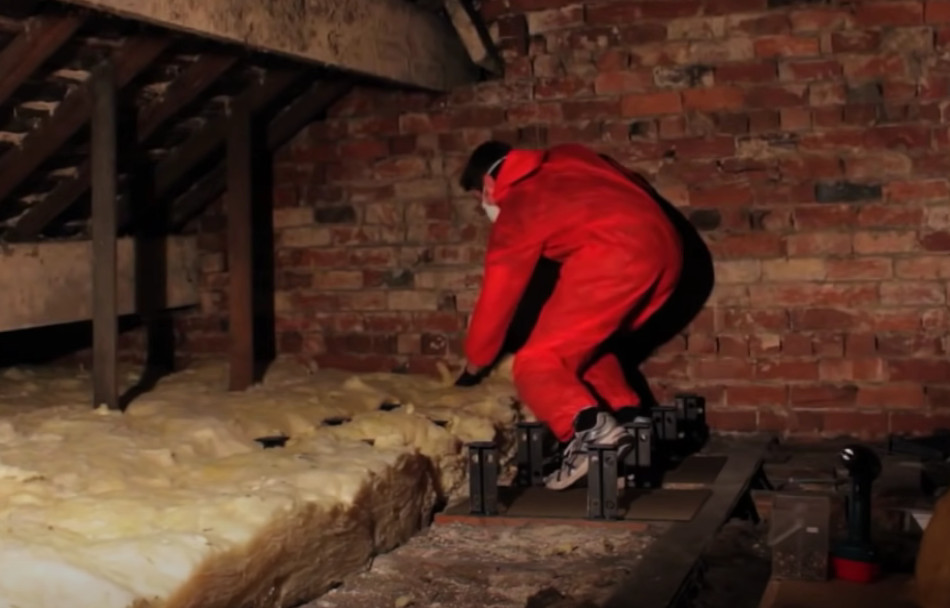 man installing loft insulation around loft legs