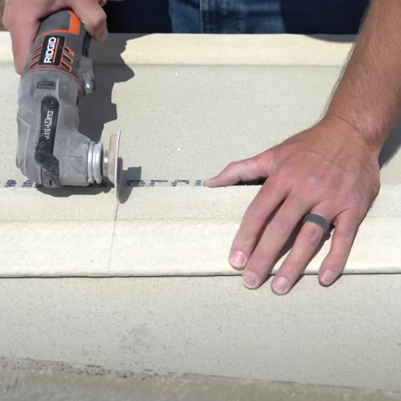 man cuts cement board with oscillating tool