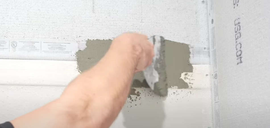 man applying adhesive to cement board joints