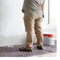 man using dust sheet when painting wall