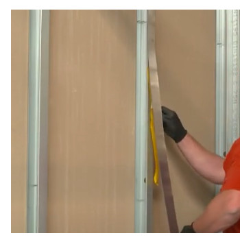 man taping lead strips to the metal frame