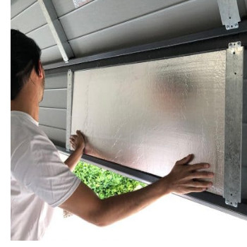 man fits insulation on garage door