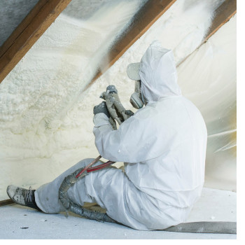 man is spraying insulation